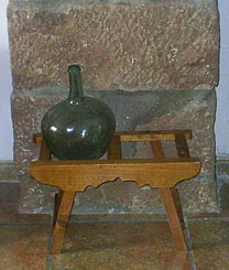 Damajuana antigua en botijero y pilar lateral de sillera